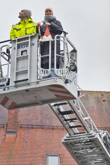 Lehrerin mit Anhänger auf Feuerwehrleiter